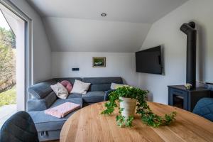 a living room with a couch and a table at Alpine Daffodil Retreat in Jesenice