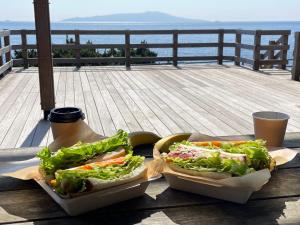 two hot dogs on a table on a deck at Lapis Jogasaki B&B in Ito