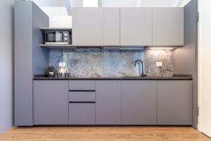 a kitchen with white cabinets and a sink at Nobel Flower Apartments in Lissone