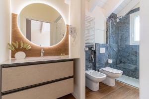 a bathroom with a sink and a toilet and a mirror at Nobel Flower Apartments in Lissone