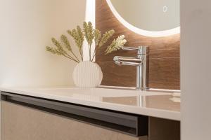 a bathroom sink with a vase with flowers in it at Nobel Flower Apartments in Lissone +132 photos