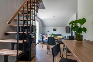 a living room and dining room with a spiral staircase at Alpine Daffodil Retreat in Jesenice