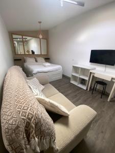 a bedroom with a bed and a couch and a desk at Like a Local Guest House in Ericeira