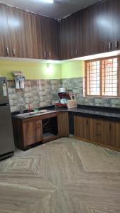 a kitchen with wooden cabinets and a counter top at Golden cypress resort with pool in Vythiri