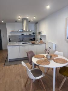 a kitchen with two tables and chairs in a room at Zentrale City Apartments in Oldenburg