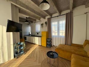 a living room with a brown couch and a kitchen at Old Town, The Reward apartment with terrace with a view in Staré Mesto