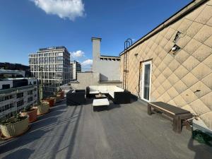 a rooftop with benches and tables on a building at Old Town, The Reward apartment with terrace with a view in Staré Mesto