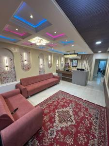 a living room with two red couches and a red rug at Hotel Crown in Dwarka