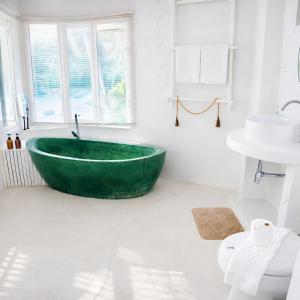 ein Badezimmer mit einer grünen Badewanne und einem Waschbecken in der Unterkunft SOLEA Beach in Nathon Bay + 36 Fotos