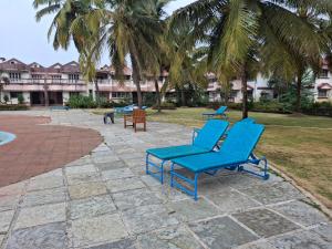 a group of blue lounge chairs on a patio at Bliss Inn in Benaulim
