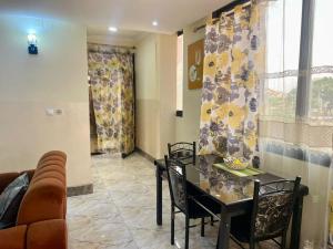 a living room with a table and chairs and a couch at DAVAROXE Appartements Lingwala RTNC in Kinshasa +19 photos