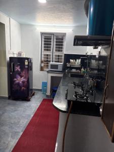 a kitchen with a stove and a refrigerator in it at Mannath lands end Beach house in Kaup