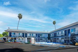 a building with palm trees in a parking lot at Motel 6-Pleasanton, CA in Pleasanton