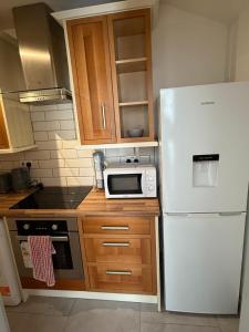 a kitchen with a white refrigerator and a microwave at Flat 4 Rylands Street in Warrington +2 photos