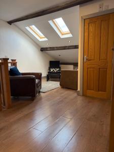 a living room with a couch and a room with skylights at Flat 4 Rylands Street in Warrington