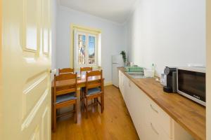 a kitchen with a table and a microwave at Casa Mariana 2 - Sintra, Apartment in Sintra +12 photos