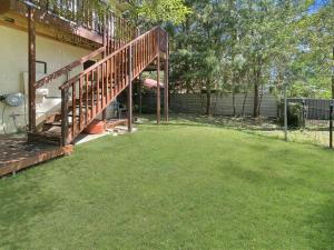 a yard with a wooden staircase next to a house at Riverside 3-Bed Townhouse with Spacious Deck in Mossy Point