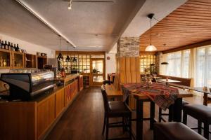 a restaurant with a bar and a table with chairs at Hotel Bergland in Sillian