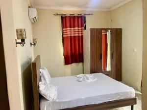 a bed in a room with a red curtain at DAVAROXE Appartements Lingwala RTNC in Kinshasa