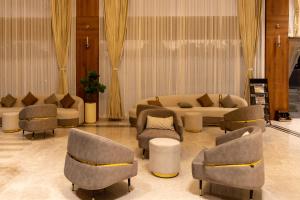 ein Wohnzimmer mit Sofas und Stühlen und einer Couch in der Unterkunft Hotel PUMERAI in Honāvar