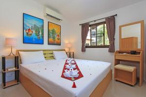 a bedroom with a large white bed and a desk at Soleil D'asie Residence in Chaweng Noi Beach
