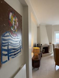 a living room with a painting on the wall at Aqui na Praia do Pedrogão in Leiria