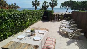 a row of tables and chairs with the beach in the background at Baconer - Casa en l'Ampolla con jardín privado y acceso directo al mar - Deltavacaciones in L'Ampolla