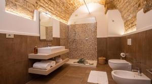 a bathroom with a sink and a toilet and a mirror at Roberto Historic House in Gubbio +12 photos