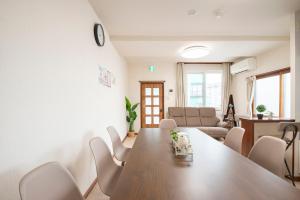 a living room with a large wooden table and chairs at Otaru Retro Villa in Otaru