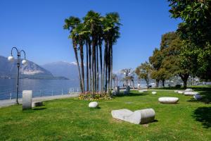 a park with rocks and palm trees and a body of water at Gigi House in Verbania