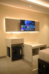a room with a desk and a tv on a wall at Mahamaya Hotel in Gohpur