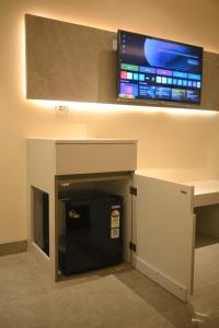a flat screen tv on a wall above a fireplace at Mahamaya Hotel in Gohpur
