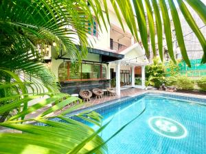 a swimming pool in a house with a palm tree at Sky Heritage Hotel in Phnom Penh