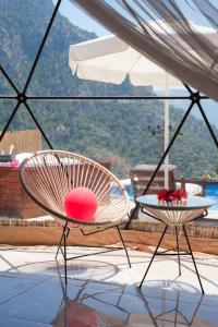 a patio with two chairs and a table at Kabak Freedom Deluxe Hotel in Faralya