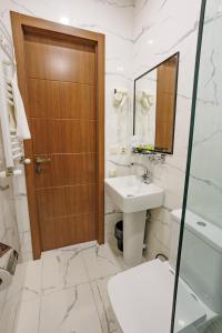 a bathroom with a toilet sink and a wooden door at City Heart Hotel in Tbilisi City +43 photos