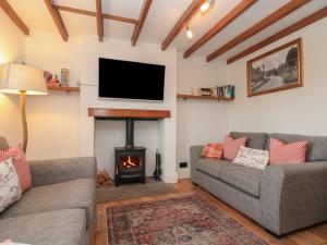 a living room with two couches and a fireplace at Isla cottage in Northallerton