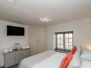 a bedroom with a bed and a tv on the wall at Isla cottage in Northallerton