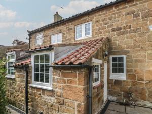 a stone house with a red roof at Isla cottage in Northallerton
