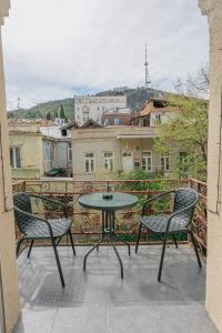 a patio with a table and chairs on a balcony at City Heart Hotel in Tbilisi City