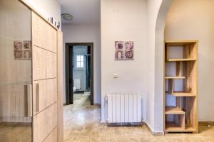 a hallway with a white wall and a radiator at Villa Aphrodite in Puigventos +44 photos