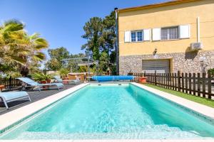 a swimming pool in front of a house at Villa Aphrodite in Puigventos