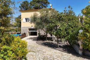 a house with a courtyard with trees in front of it at Villa Aphrodite in Puigventos