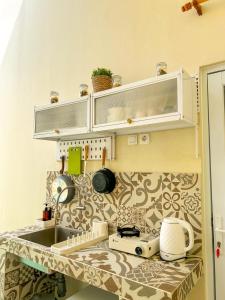 a kitchen with a sink and a counter top at At Paviliun With Private Pool in Timuran