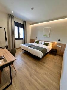 a bedroom with a bed and a table and a desk at Hotel Síbel Baza in Baza
