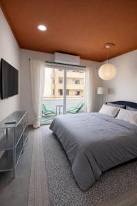 a bedroom with a large bed and a large window at Top Location Studios - Avra, Boreio and Kyma in Larnaca