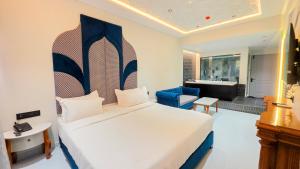 a bedroom with a bed and a living room at Hotel Nova Bloom in Ahmedabad