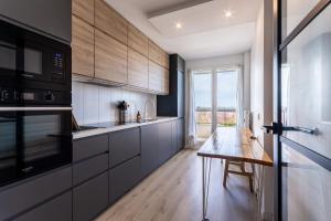 a kitchen with a wooden table and a large window at Nouveau - Horizons - Vue mer in Saint-Nazaire +6 photos