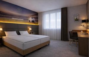 a bedroom with a bed with a soccer ball on the wall at Tulip Inn Hotel Düsseldorf Arena - 2 Minuten Fußweg zur Messe in Düsseldorf