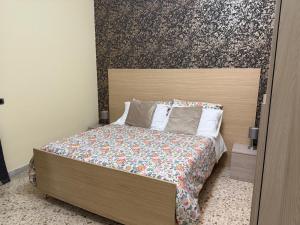 a bedroom with a bed with a wooden headboard at Pompei Sanctuary rooms in Pompei