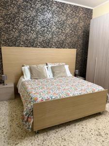 a bedroom with a large bed with a wooden headboard at Pompei Sanctuary rooms in Pompei